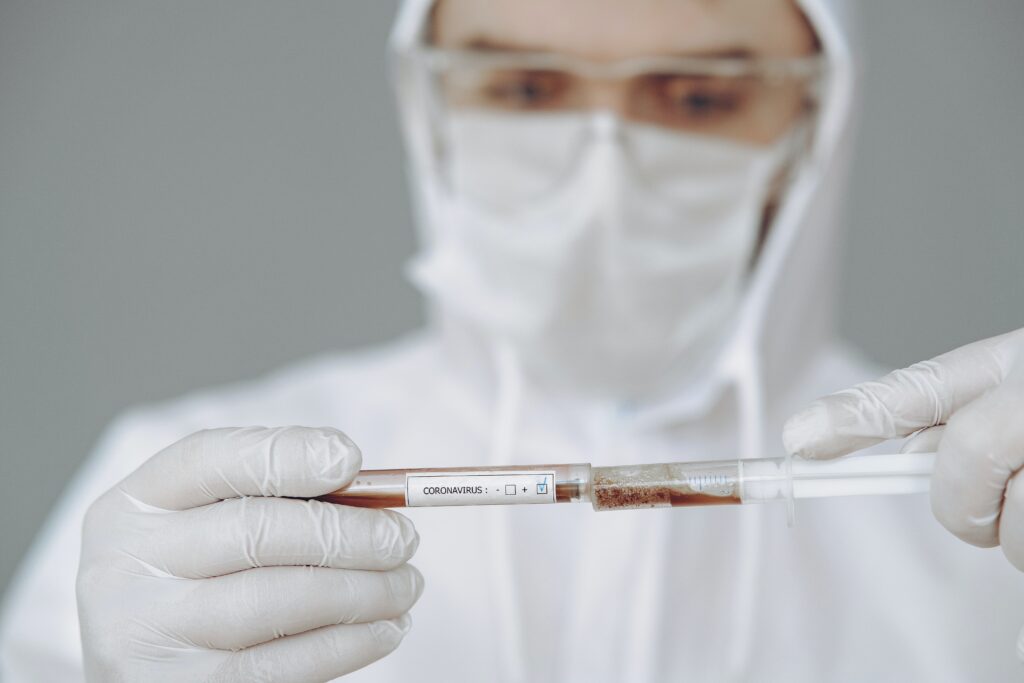 Healthcare worker in PPE demonstrating safe practices to prevent risk of exposure to bloodborne pathogens in a professional medical setting