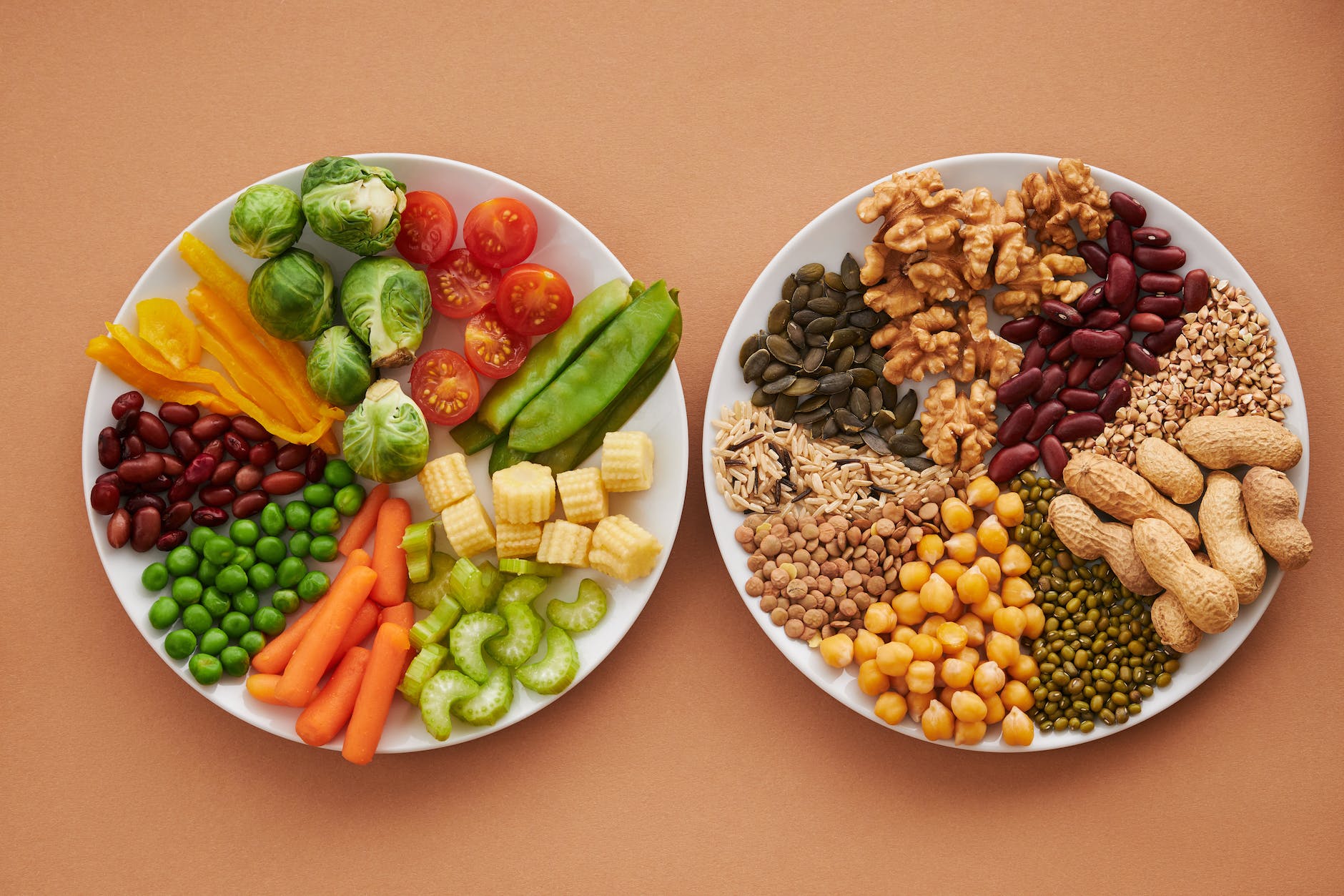 plate of assorted vegetables beside a plate of nuts and beans